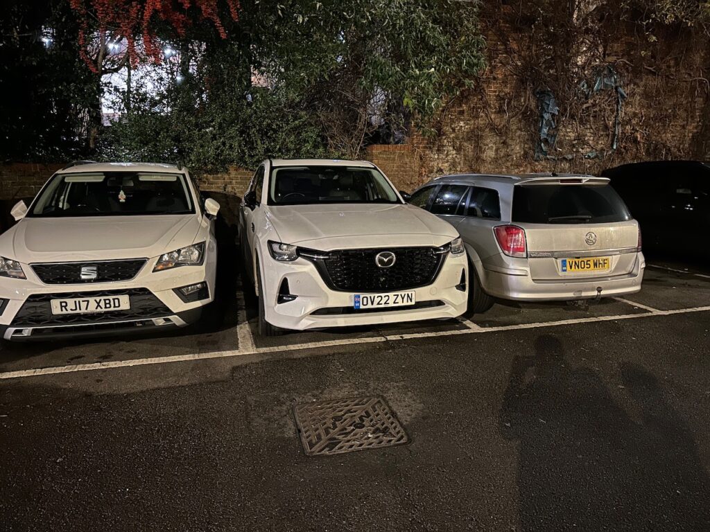 White Mazda CX60 PHEV parked in tight car park space