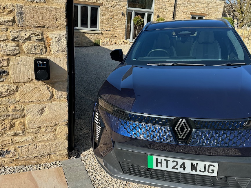 Blue Renault Scenic next to Ohme EV charger