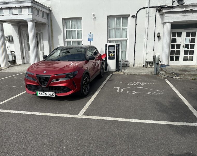 Red Alfa Romeo Junior plugged in to BP Pulse charger